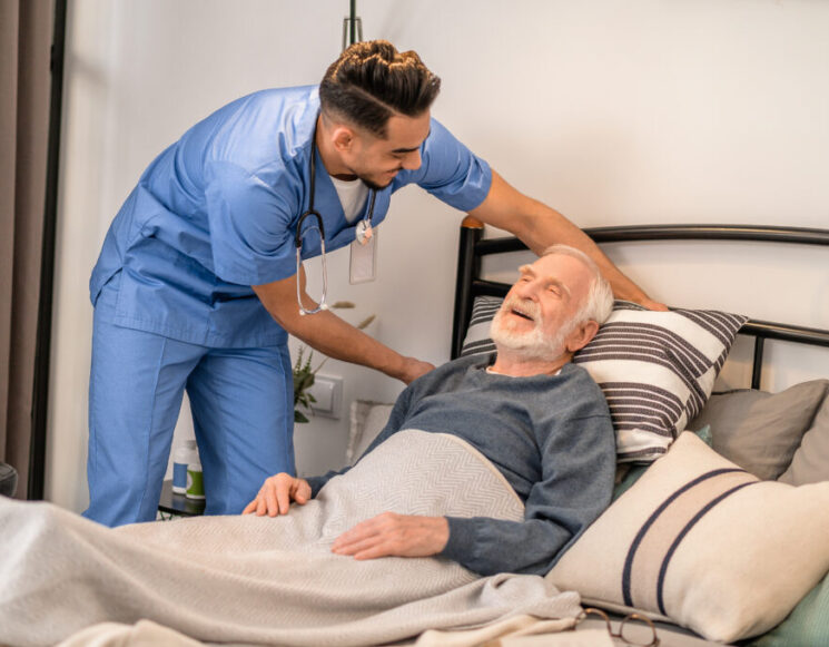 Experienced nurse positioning the patient in bed