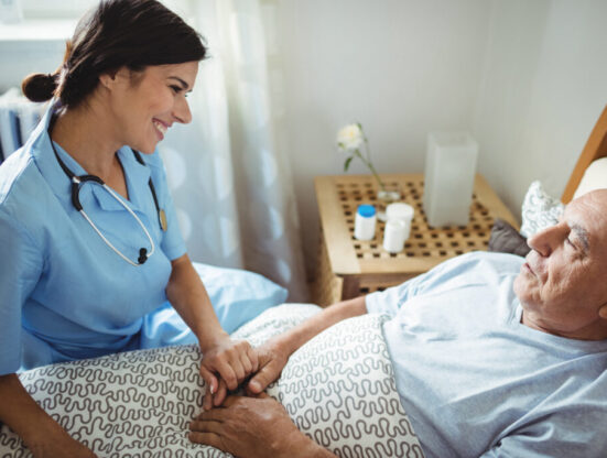Nurse holding hands of senior man